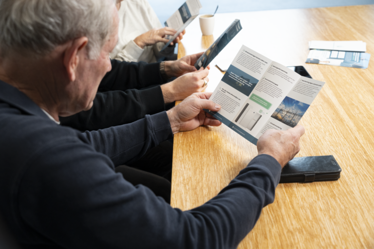 Klanten lezen samen met een adviseur de offerte door