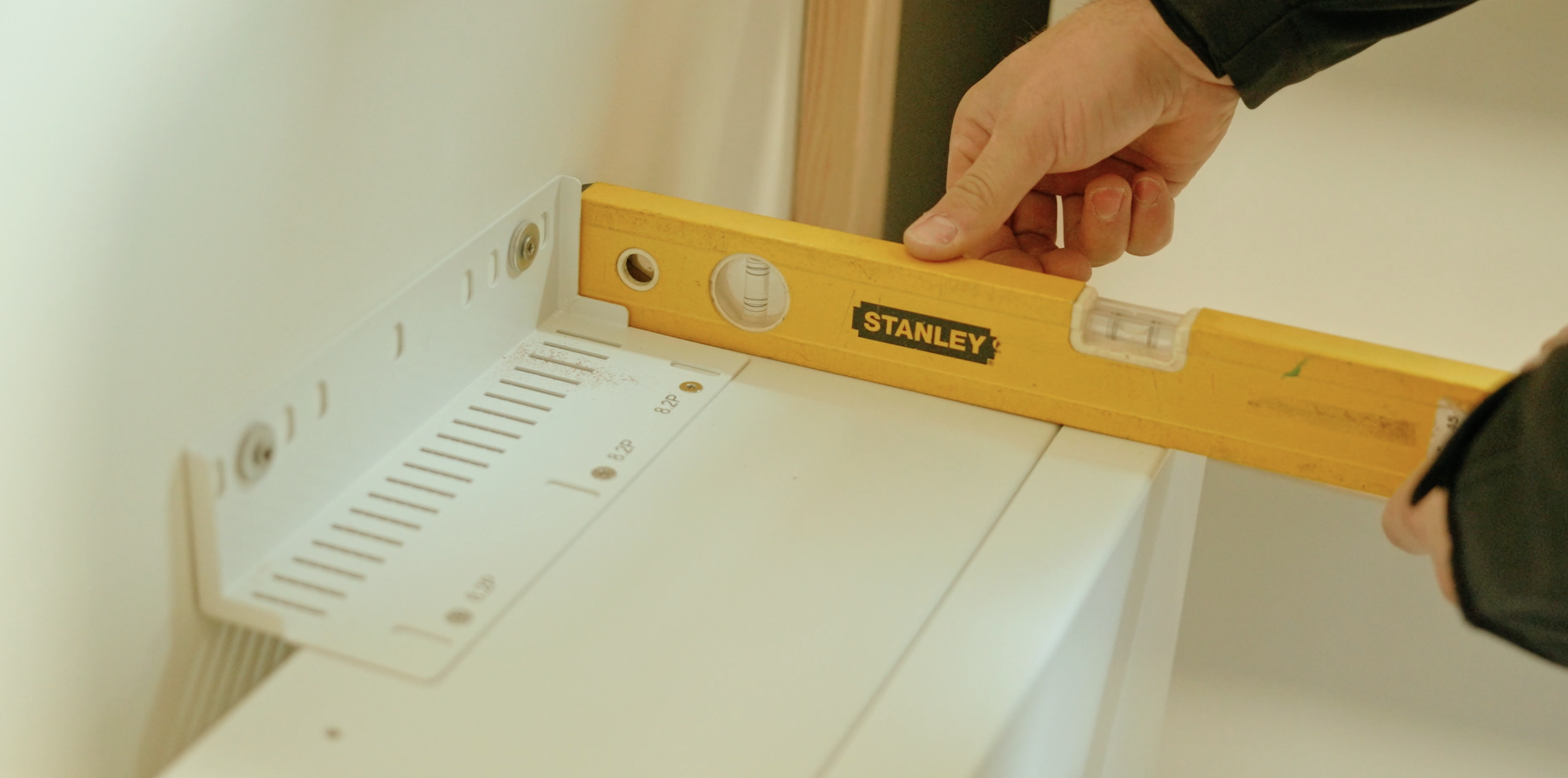 Monteur van ThuisbatterijNederland.nl stelt een thuisbatterij waterpas af tijdens de installatie