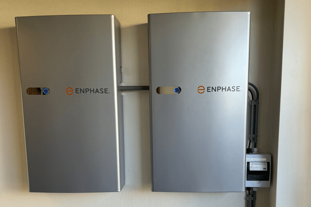Twee afgewerkte Enphase-thuisbatterijen aan de muur bij een klant