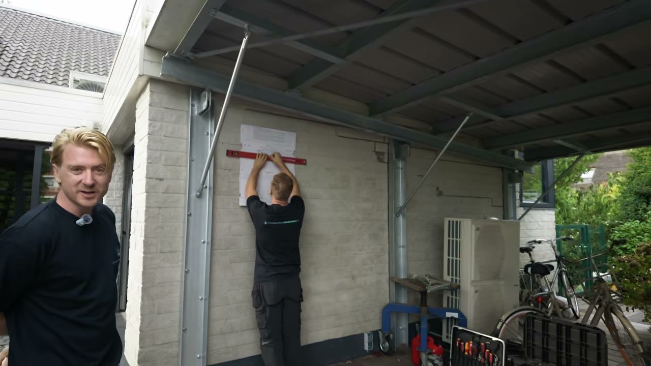 Monteur tekent met waterpas en mal af waar de batterij komt