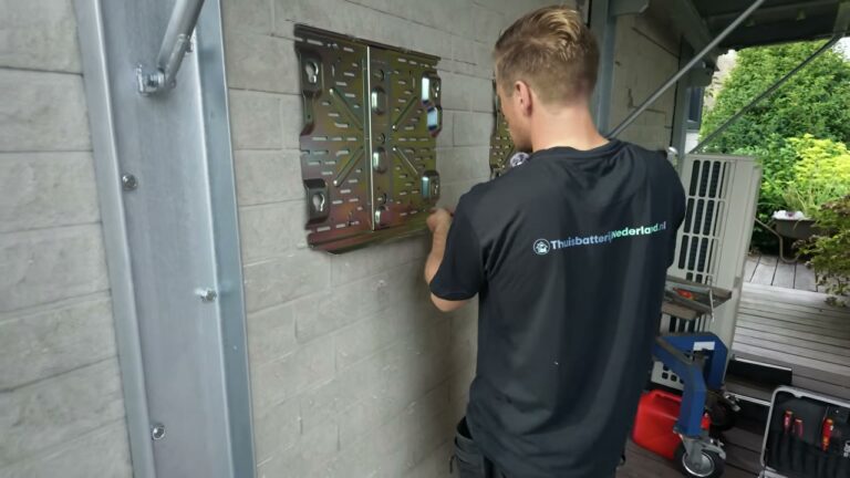 Monteur van ThuisbatterijNederland.nl hangt een thuisbatterij aan de muur