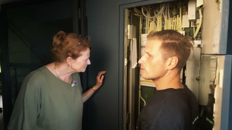 Specialist bekijkt met de bewoner de meterkast