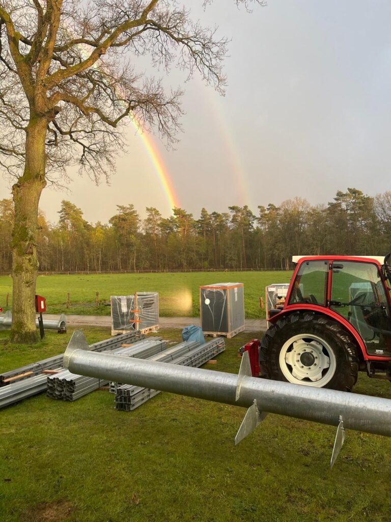 Een dubbele regenboog boven een eMove-veld in opbouw